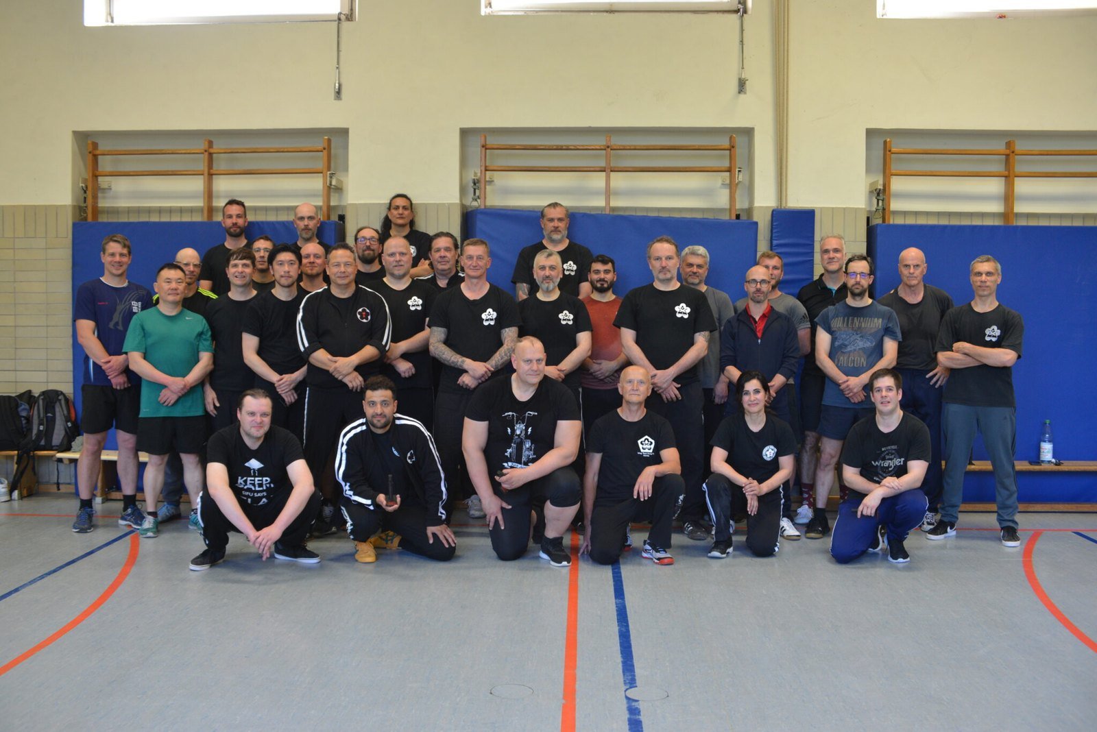 Foto de grupo de los participantes en el encuentro del veinte aniversario de Kampfwerk, en un gimnasio.