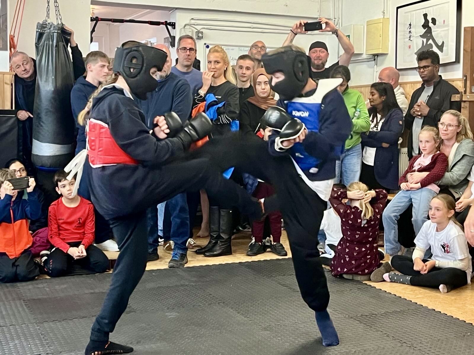 Dos jóvenes con casco, guantes y protecciones durante un encuentro ante el público en Schriesheim.